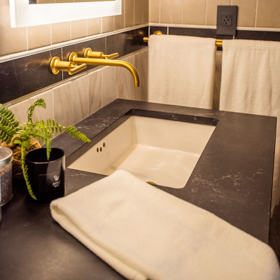 Chip Wades residential renovation, Pinhoti Peak, ADU bathroom with black quartz countertop, backsplash of white marble look tile, black marble look tile, and gray wall tile.