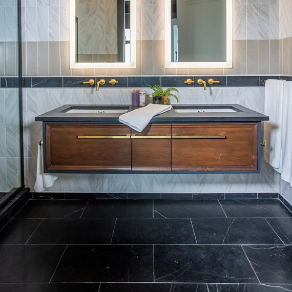 Chip Wades residential renovation, Pinhoti Peak, ADU bathroom with black quartz countertop, backsplash of white marble look tile, black marble look tile, and gray wall tile.
