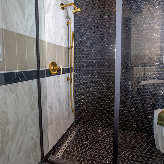 Chip Wades residential renovation, Pinhoti Peak, ADU shower wall and shower floor with black marble mosaic tile, white wall tile and gray wall tile that look like marble.