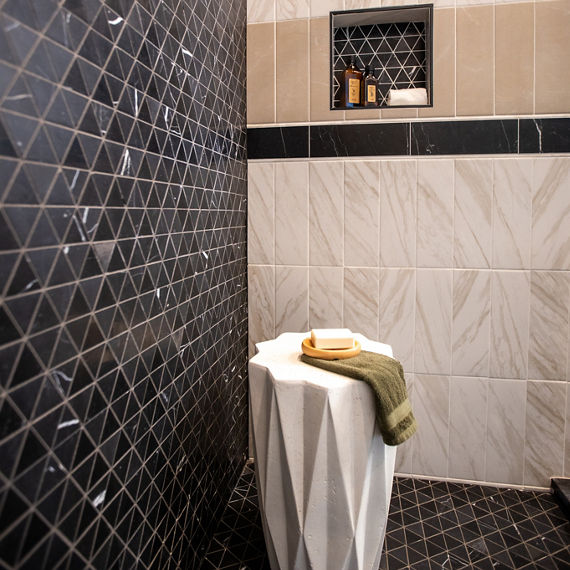 Chip Wades residential renovation, Pinhoti Peak, ADU shower wall and shower floor with black marble mosaic tile, white wall tile and gray wall tile that look like marble.