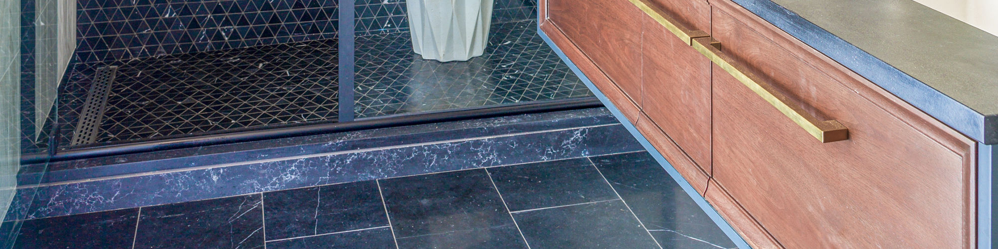 Chip Wades residential renovation, Pinhoti Peak, ADU shower wall and shower floor with black marble mosaic tile, white wall tile and gray wall tile that look like marble.