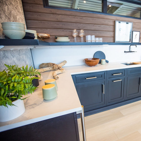 Chip Wades residential renovation, Pinhoti Peak, ADU kitchen with white quartz countertop and backsplash, natural wood shiplap, and black floating shelf.