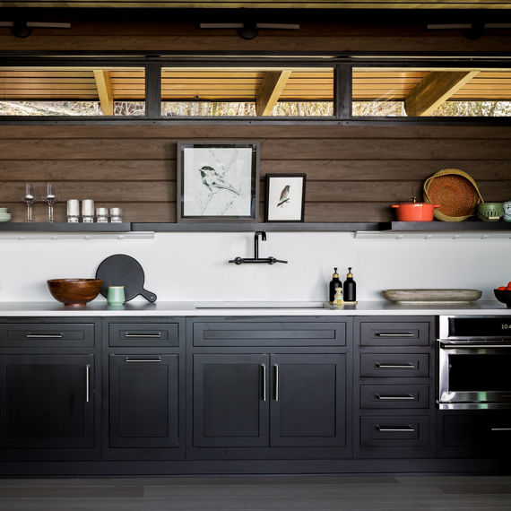 Chip Wades residential renovation, Pinhoti Peak, ADU kitchen with white quartz countertop and backsplash, natural wood shiplap, and black floating shelf.