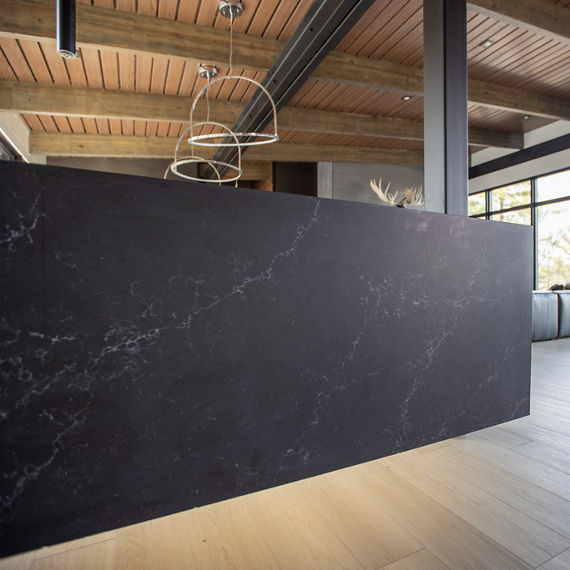 Chip Wades residential renovation, Pinhoti Peak, open kitchen, dining room, living room with black quartz countertops, white glossy wall tile, and floor to ceiling windows.