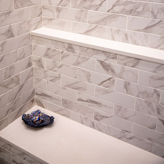 Chip Wades residential renovation, Pinhoti Peak, master bathroom shower with white and gray marble look tile and white quartz shower bench and shelving.