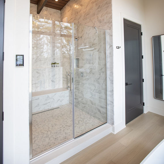 Chip Wades residential renovation, Pinhoti Peak, master bathroom shower with white and gray marble look tile and white quartz shower bench and shelving.