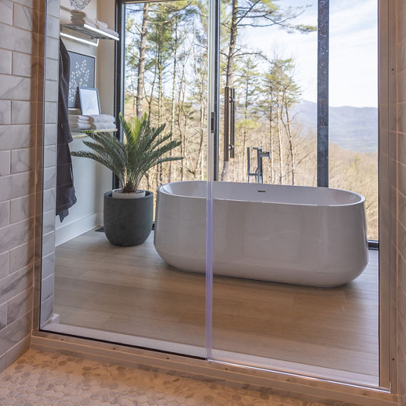 Chip Wades residential renovation, Pinhoti Peak, master bathroom shower with white and gray marble look tile and white quartz shower bench and shelving.