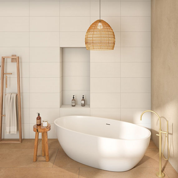 Minimalist bathroom with soaker tub on slip resistant terracotta look floor tile, antimicrobial off white wall tile with niche, and wicker pendant lighting.