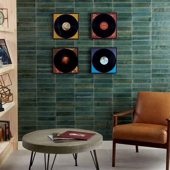 Room with records on wall, light wood shelves, and green rectangle wall tile.