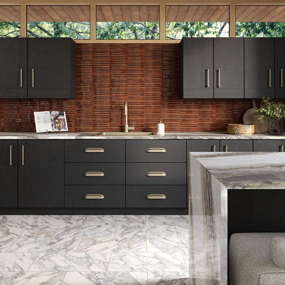 Kitchen with orange fluted rectangle tile on back wall, black cabinets, white marble look countertops, and white marble look rectangle floor tile.