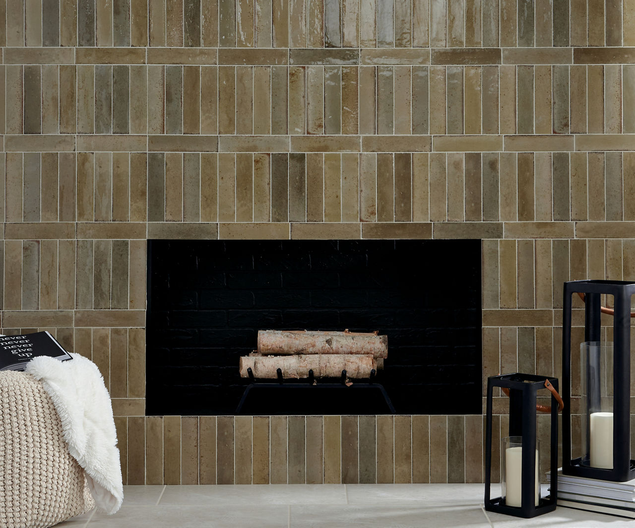 Fireplace with logs inside, white concrete look rectangle floor tile, and light brown subway tile surrounding fire place.