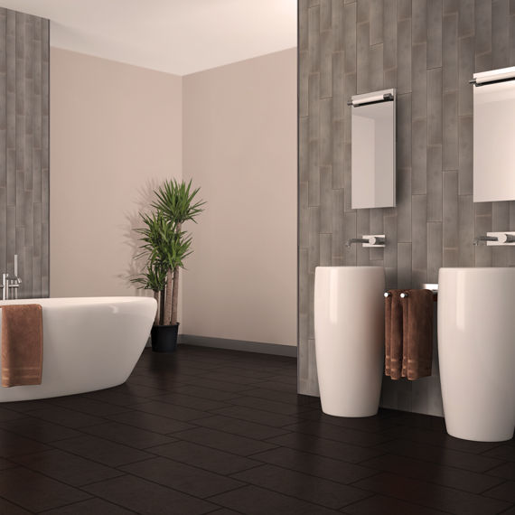 Spacious bathroom with tall ceilings accentuated by metallic-look linear tile arranged in a vertical pattern. Soaker tub and double vanity in curvy shapes.