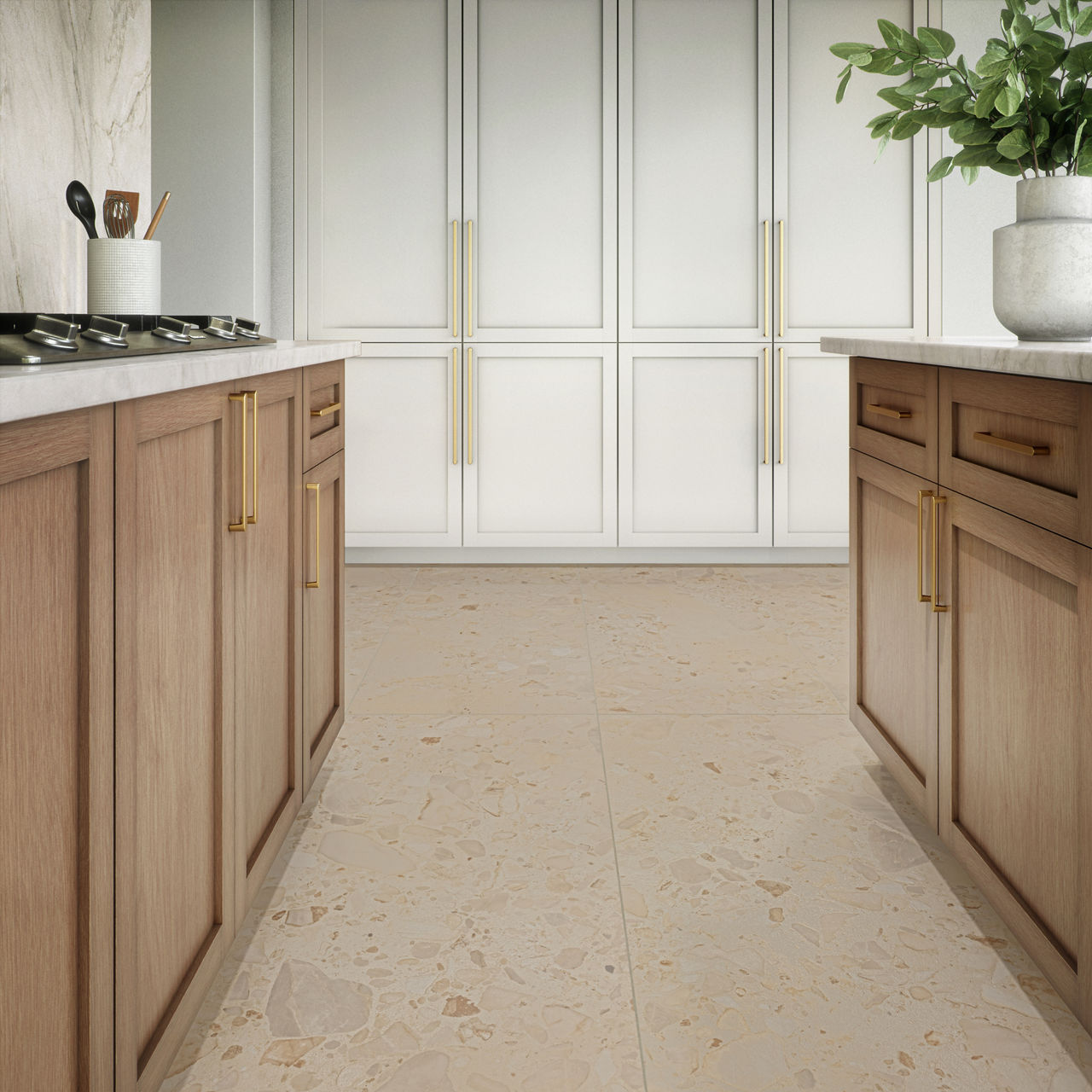 Contemporary kitchen interior featuring light wood lower cabinets with gold handles and white upper cabinetry. The space is designed in a galley layout with countertops on both sides and a central walkway. A neutral stone or terrazzo-style floor runs