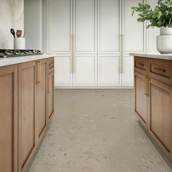 A contemporary kitchen features light wood cabinets with gold handles and a marble countertop