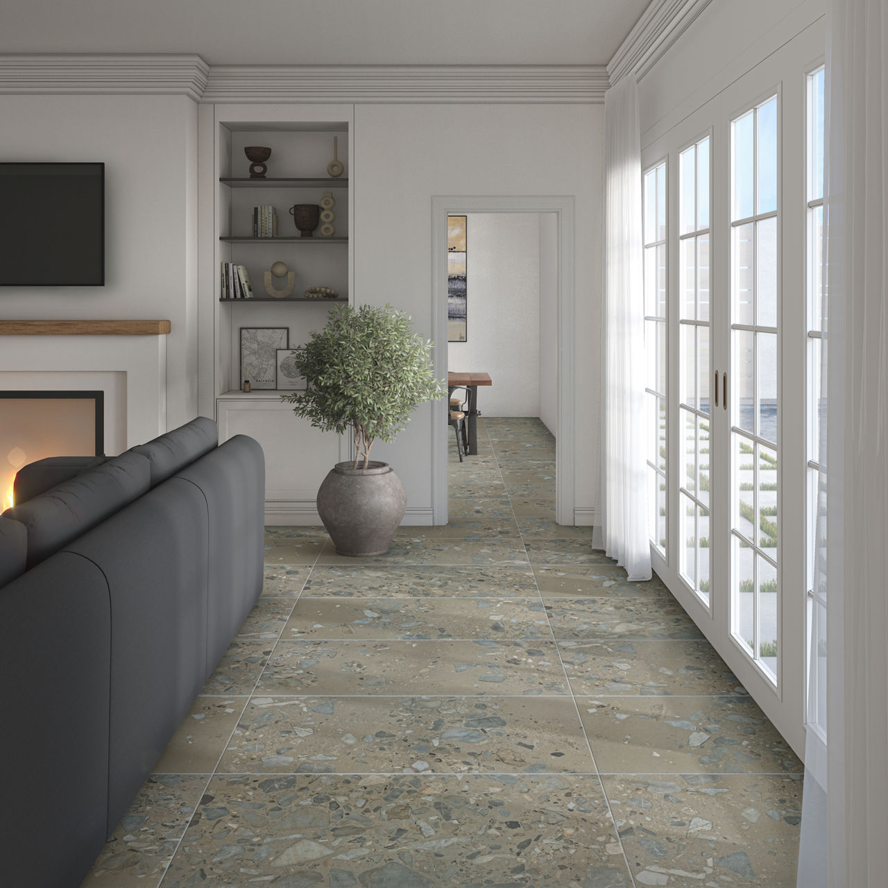 A contemporary living room features large stone-look floor tiles with a speckled, terrazzo-style pattern. A dark sofa faces a wall-mounted television above a minimalist fireplace, while built-in shelves display decor items. Tall glass doors on the ri