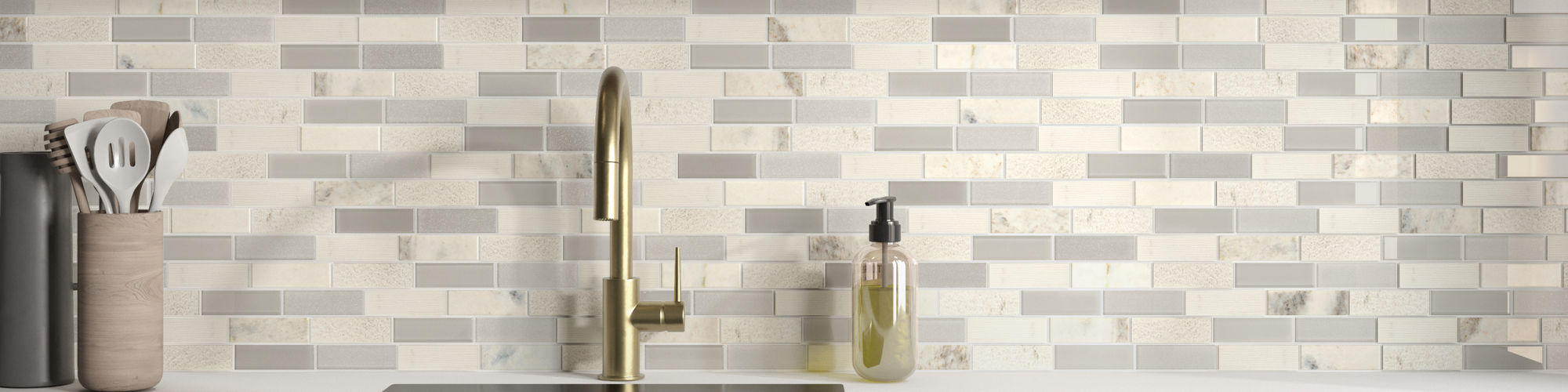 Kitchen with white natural stone rectangle mosaic on backsplash, white counter, gray cabinets, and wood shelf with greenery.