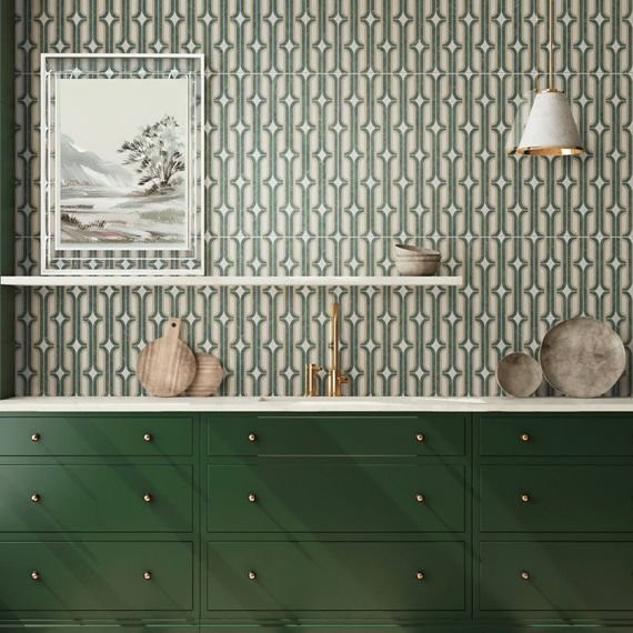 Kitchen with green cabinets, green encaustic mosaic on backsplash and wall, white countertop, and gold accents.