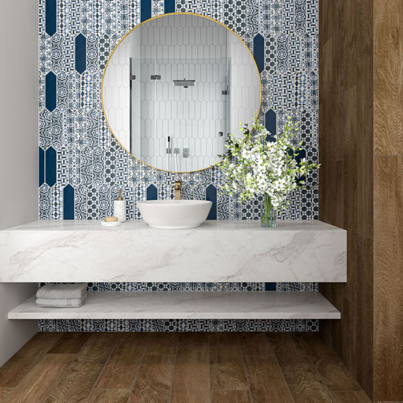 Bathroom with encaustic picket tile on back wall, marble counter, wood floor, and circle mirror above sink.