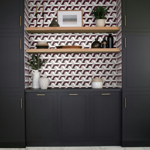 Wet bar with pink mosaic wall tile in a pinwheel patter, black cabinets, and white marble look floor tile.