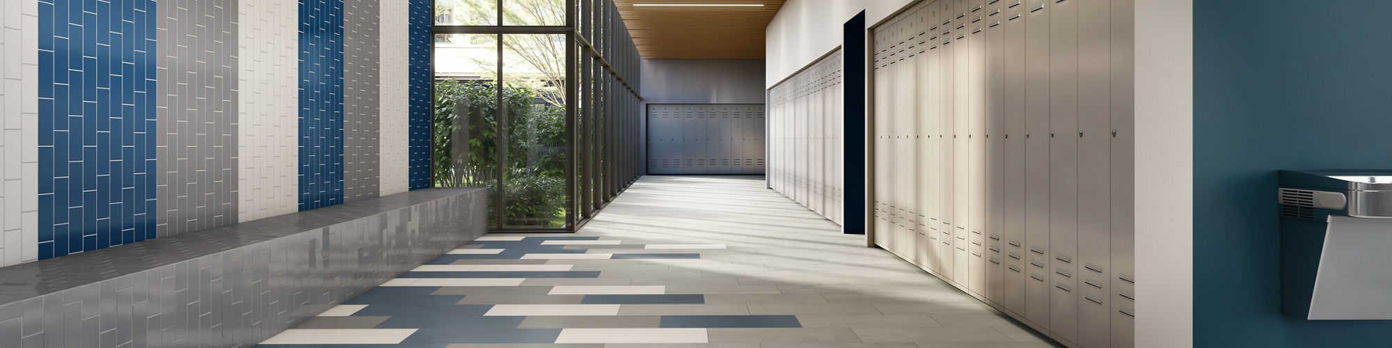 Hallway with gray rectangle concrete look floor tiles, white and blue rectangle floor tiles, and white, blue, and gray walls.