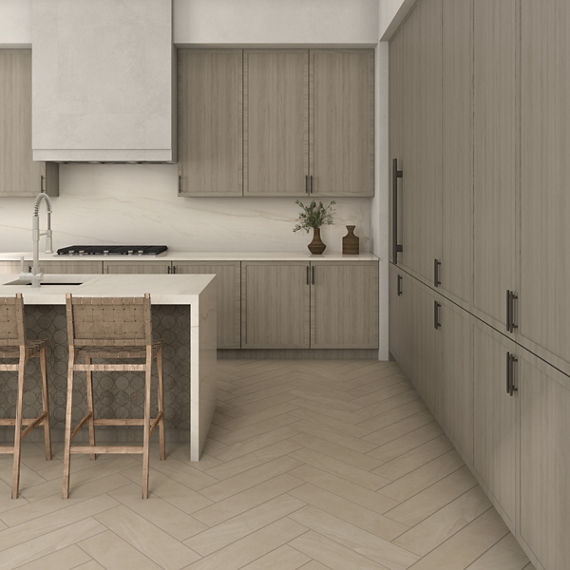 Kitchen with beige stone look rectangle floor tile in herringbone pattern, white quartzite countertop and backsplash, and beige wood cabinets.