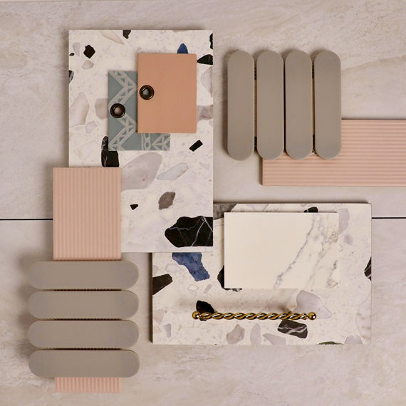 This flatlay contains a white marble look rectangle tile, white rectangle terrazzo look tile, pink rectangle linear wall tile, gray capsule mosaic, and a white marble look quartz slab.