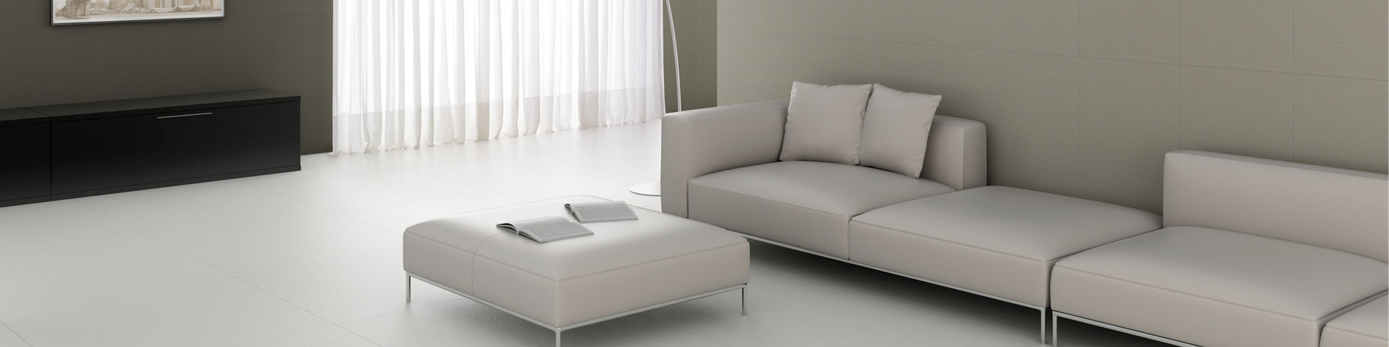 Ultra modern living room with light gray floor tile, darker gray wall tile, light gray sectional sofa and ottoman, floor lamp, and white sheers covering floor to ceiling window.