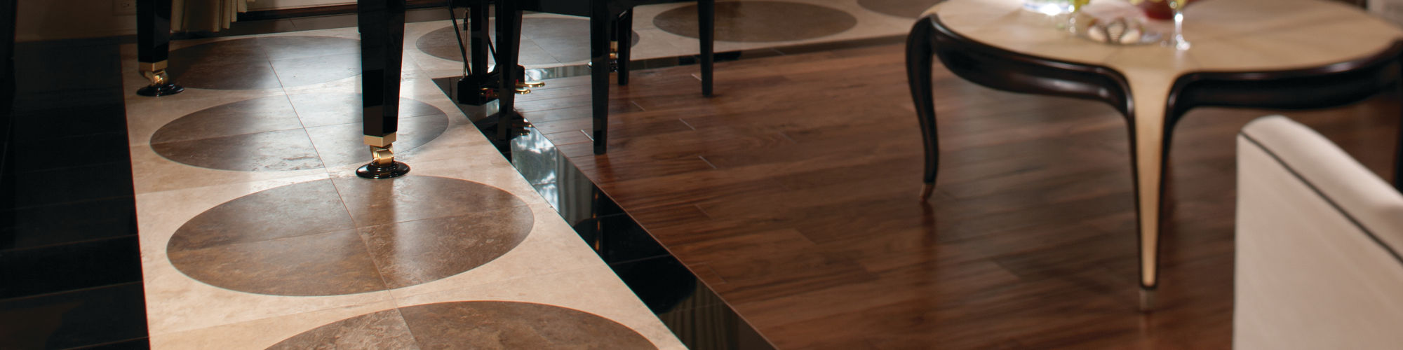 Elegant living room with accents of black granite, beige and white travertine floor tile, black baby grand piano, dark and light wood coffee table.