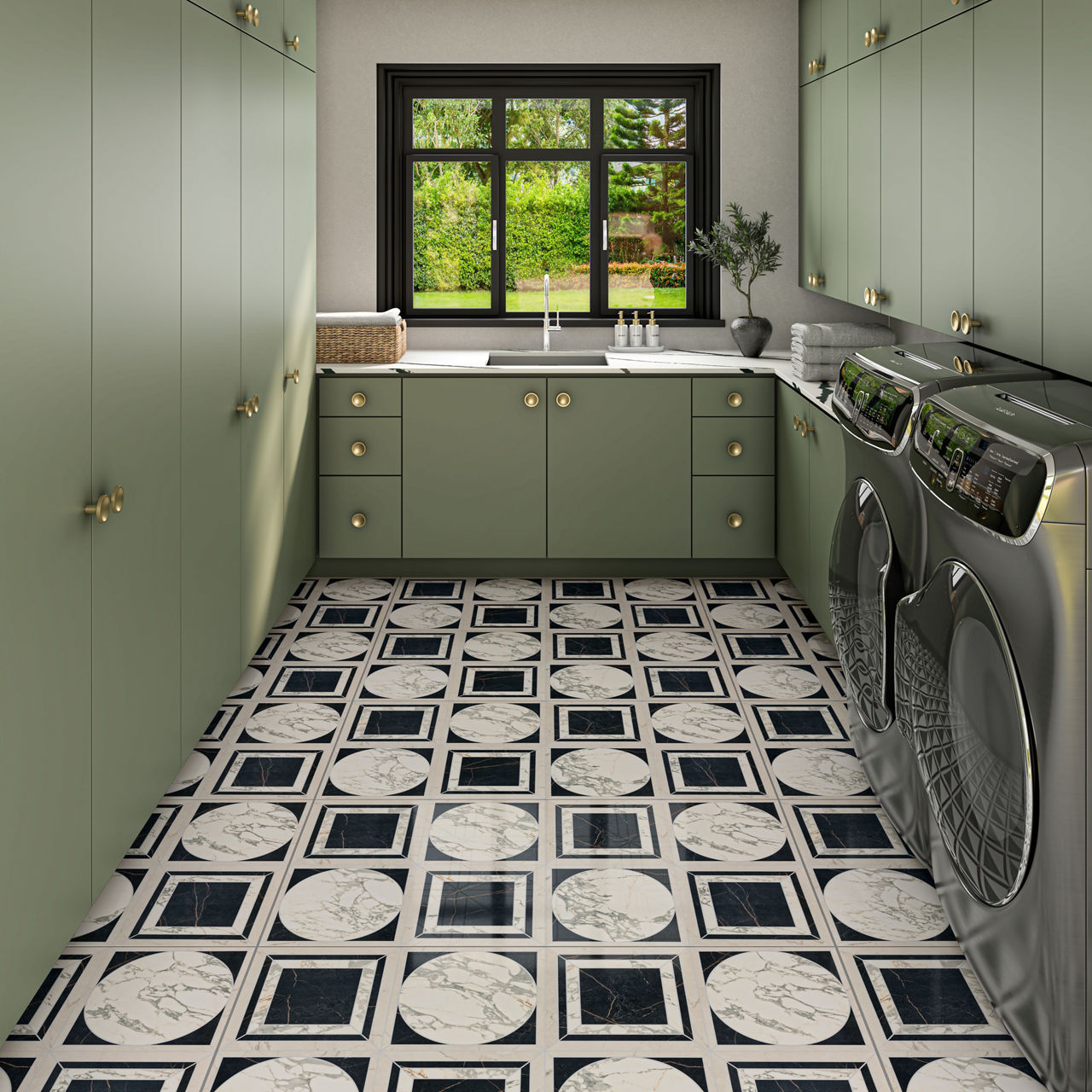 A contemporary laundry room features sage green cabinets with gold hardware and a striking black and white geometric tile floor. Stainless steel washer and dryer units are positioned on the right, while a large window above the sink offers a view of 