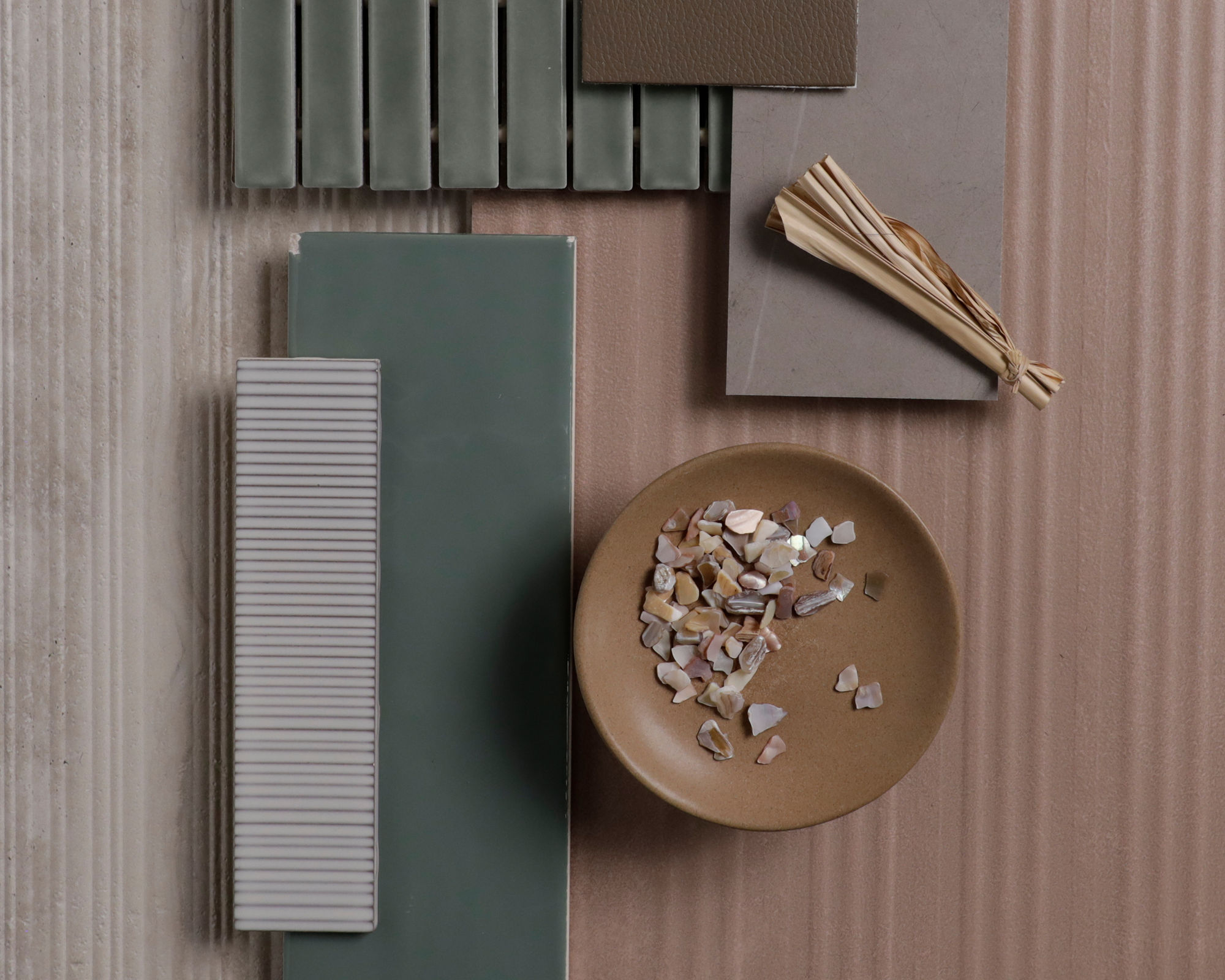 Flatlay with orange wall look layered tile, beige stone look fluted tile, cream wall look rippled rectangle tile, green wall look rectangle mosaic, green wall look rectangle tile, and a gray stone look slab.