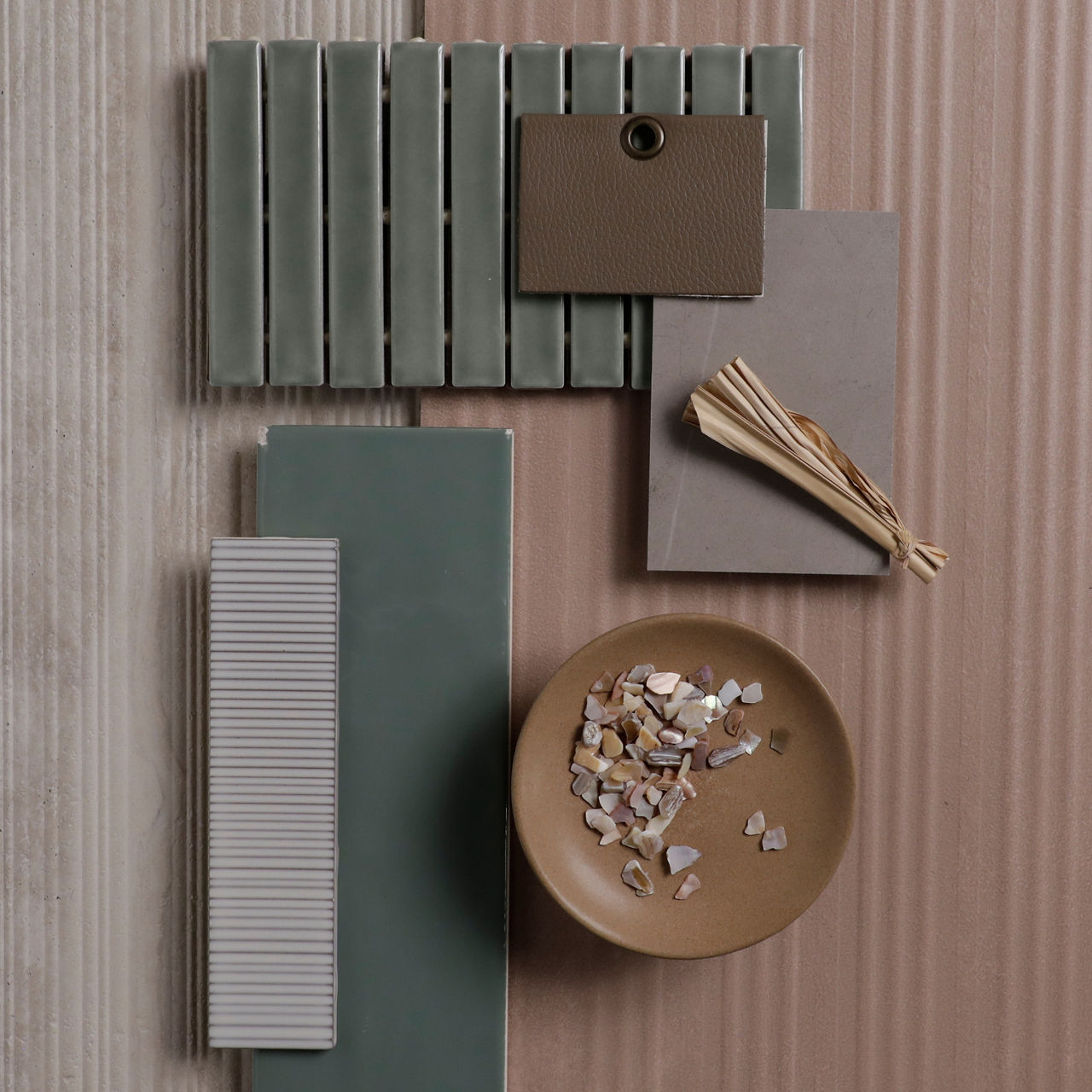 Flatlay with orange wall look layered tile, beige stone look fluted tile, cream wall look rippled rectangle tile, green wall look rectangle mosaic, green wall look rectangle tile, and a gray stone look slab.