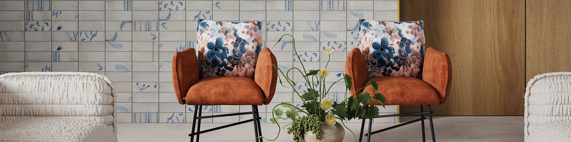 Waiting area with white and blue encaustic rectangle wall tile, wood side wall, beige fabric look rectangle floor tile, two white couches, wooden center table, and two orange chairs.