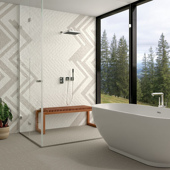 Bathroom with white and gray rectangle tile on back wall, gray hexagon floor tile, white tub, and floor to ceiling window on back wall.