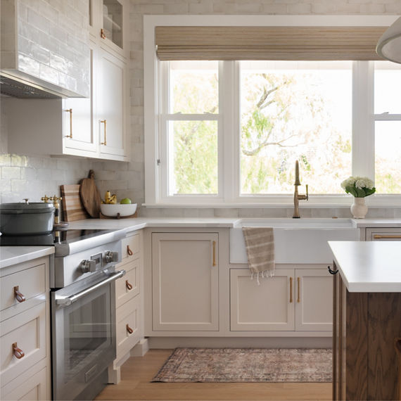 Kitchen with white cabinets, white subway tile on backsplash, and white countertop.