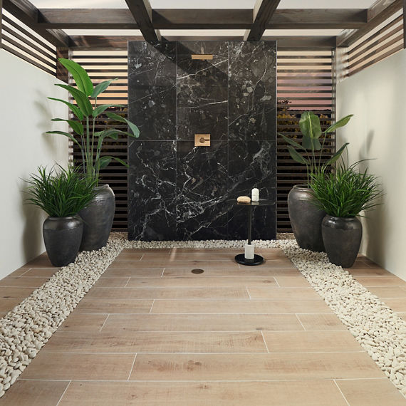 Outdoor shower with black rectangle marble look tile on shower wall, and wood look tile on floor.