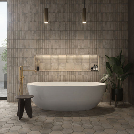 Bathroom with light brown rectangle cotto look tile on back wall, light brown cotto look hexagon floor tile, white tub, and light brown square cotto look tile in wall niche.