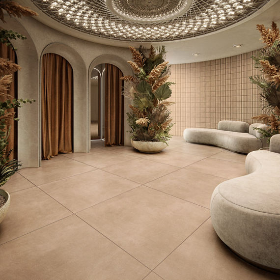 Dressing room waiting area with beige large format square concrete look floor tile, white couches, three dressing rooms with orange curtains, and a large vase with greenery.