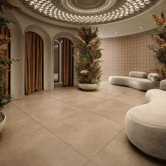 Dressing room waiting area with dark beige large format square concrete look floor tile, white couches, three dressing rooms with orange curtains, and a large vase with greenery.