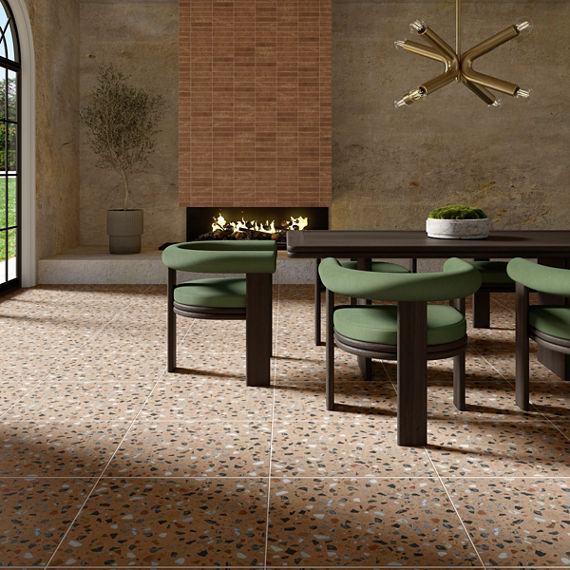Dining room with orange terrazzo look square floor tile, green dining chairs, dark wooden dining table, and a fireplace in the back.