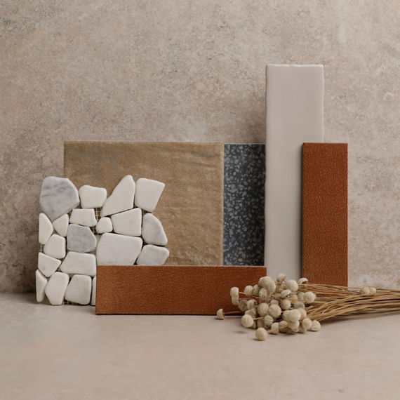 This flatlay contains a white rectangle wall tile, red rectangle wall tile, white pebble mosaic, and beige stone look square tile.