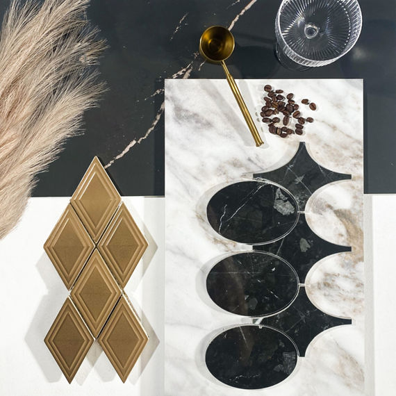 This flatlay contains black marble look floor tile, white rectangle marble look floor tile, gold harlequin metal look mosaic, and black marble look circle mosaic.