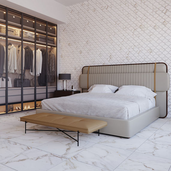 Bedroom with white square marble look floor tile, white arabesque marble look tile on wall, see through closet on left side of wall, and white bed in middle.