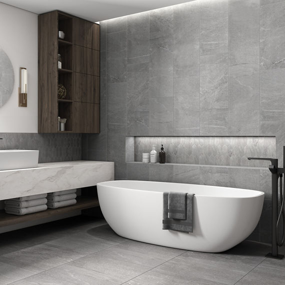 Bathroom with gray marble look rectangle tile on floor, gray marble look square tile on walls, gray marble look picket mosaic on backsplash, white tub, and marble look porcelain counter.