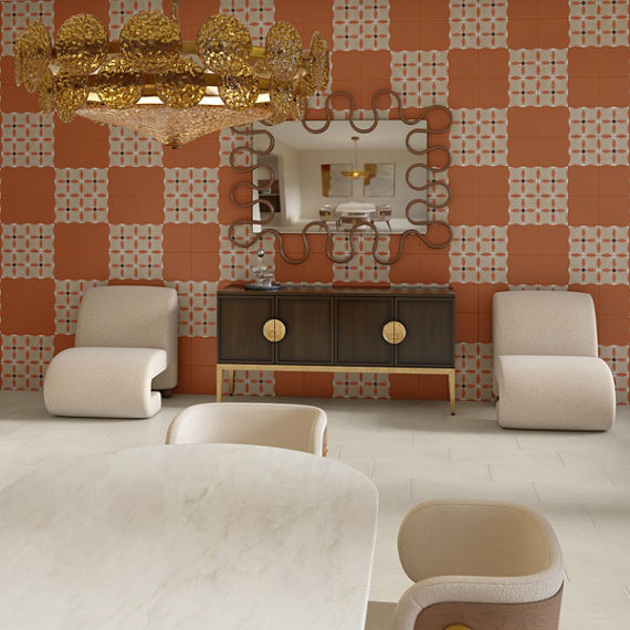Dining room with orange and encaustic square tile on back wall, white rectangle stone look tile on floor, and white chairs.
