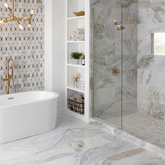 Bathroom with white marble look rectangle floor tile, white marble look rectangle tile on shower walls, white marble mosaic on back wall, and white marble look pebble mosaic on shower floor.