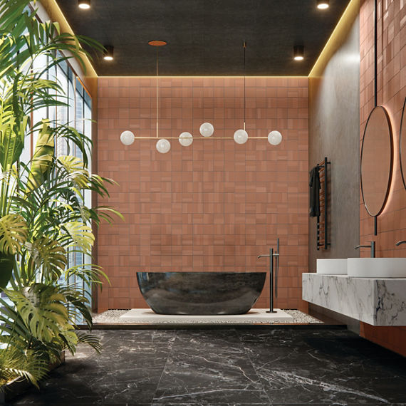 Bathroom with orange undulated square tile on back wall, black marble look square floor tile, white marble counter, and greenery on side of room.
