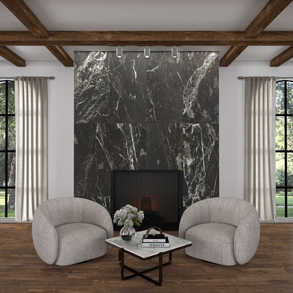 Living room with gray marble look tile on fireplace surround, wood look floor tile, two gray chairs, white walls, and two large windows showing the outdoors.