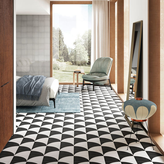 Bedroom with black and white concrete look encaustic tile on floor, gray square tile on back wall, and wood accents.