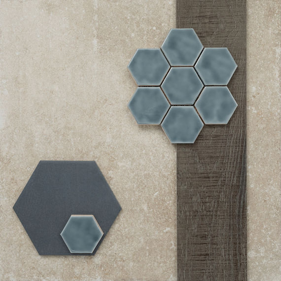 This flatlay contains a stone look tile accented by a wood look plank, undulated hexagon mosaic, and a stone look hexagon tile.
