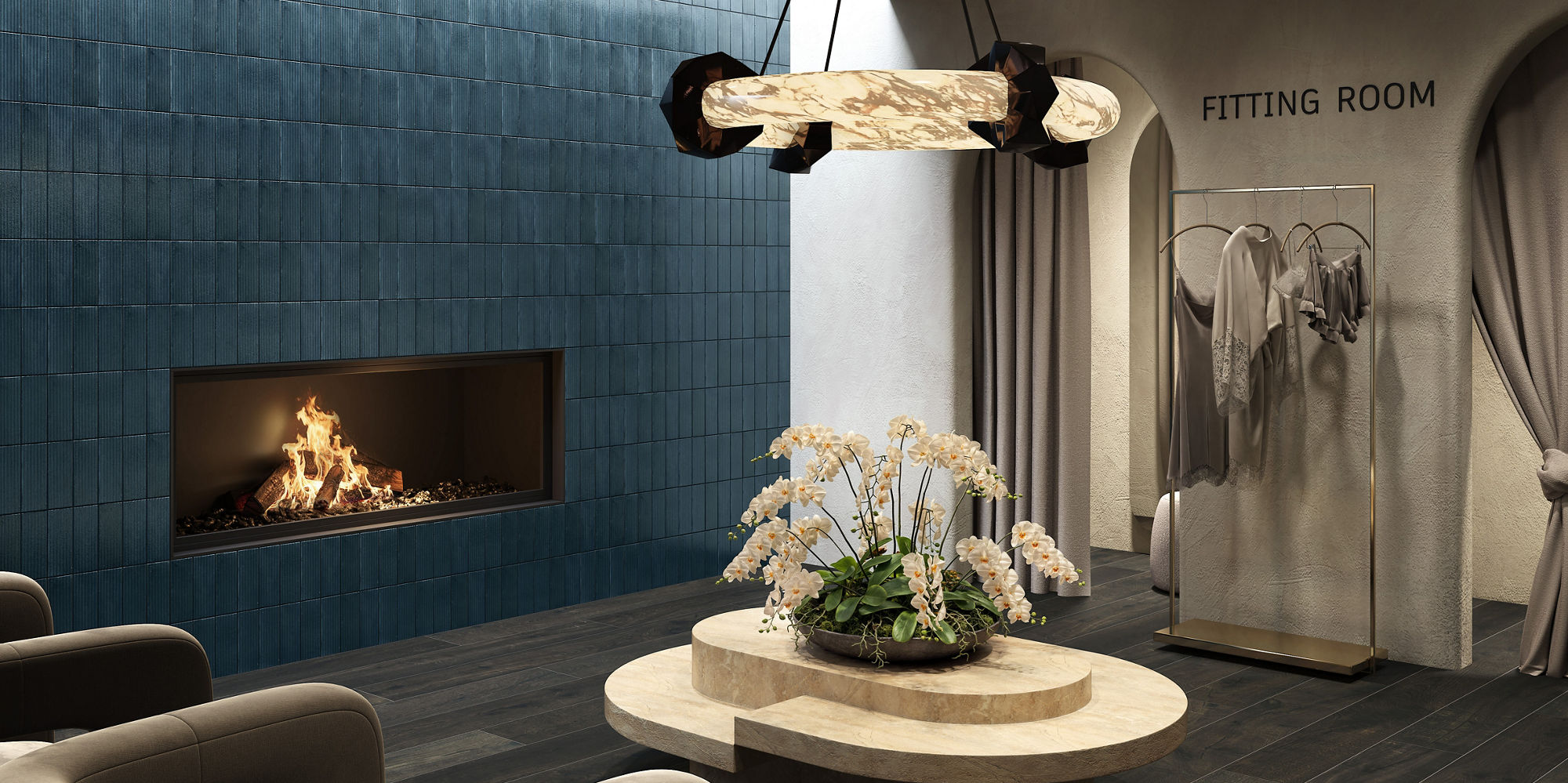 Fitting room waiting area with dark wood look floor tile, blue rectangle tile on side wall, fireplace, two gray chairs, and beige coffee table in center.
